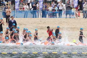 オープンウオータースイミング個人１キロの部。合図で海に飛び込み、泳ぎ出す出場者（２日、和歌山県田辺市扇ケ浜で）