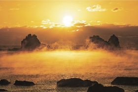 朝日を浴びて黄金色に輝く海霧（９日午前７時過ぎ、和歌山県串本町田原で）