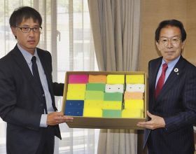 井澗誠町長（右）にキッチンスポンジを渡す筈谷蔵太代表取締役＝和歌山県白浜町で