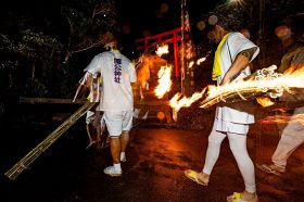 火の付いたたいまつを持ち、階段を駆け上がる若者ら（８日、和歌山県串本町樫野で）