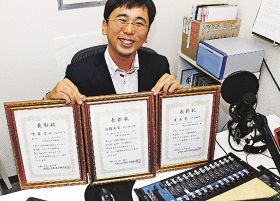 コンテスト３部門の表彰状を手に喜ぶＦＭ田辺営業・制作の大崎健志さん（和歌山県田辺市宝来町のスタジオで）