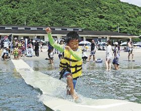 水上ゴザ走りに挑戦する子ども（３０日、和歌山県串本町くじの川で）