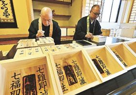 節分会で使う祝枡に年号を書き入れる青岸渡寺の高木亮英住職（左）ら＝１４日、和歌山県那智勝浦町で