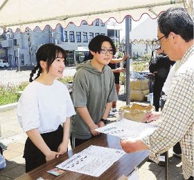 来場者（右）を会場本部で案内する田辺高校シーカーの生徒