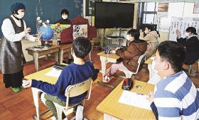 紙芝居などを使って児童に松原安太郎さんやブラジルについて紹介する岩本恵子さん（左）と出口征子さん＝和歌山県みなべ町土井で