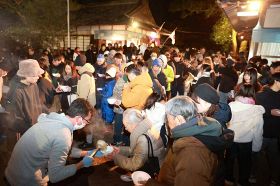 初詣後に熱々の雑煮の振る舞いを楽しむ参拝者ら（１日、和歌山県白浜町の熊野三所神社で）