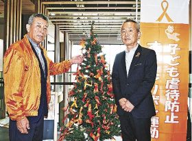 木村晃和副市長（右）が立ち会い、山本高正副会長らが設置したオレンジリボンのツリー＝和歌山県田辺市役所で