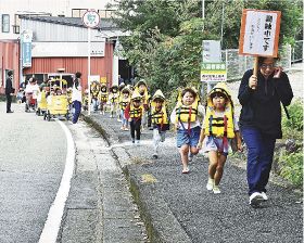 ライフジャケットを着て高台へ避難する芳養保育所の園児ら（５日、和歌山県田辺市芳養松原２丁目で）