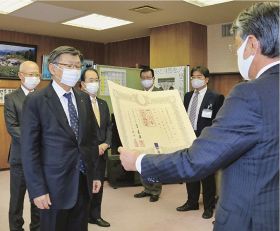 真砂充敏市長（右）から紺綬褒章の伝達を受ける榎本長治会頭（左から２人目）と金谷清道副会頭（左）、中田吉昭副会頭（左から３人目）＝１５日、和歌山県田辺市の市長室で