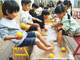 ユズの足湯を楽しむ子どもたち（２０日、和歌山県みなべ町南道で）