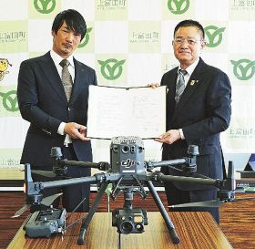 災害時などにおける無人航空機の運用に関する協定を結んだナカト産業の中井政斗代表（左）と上富田町の奥田誠町長＝上富田町朝来で