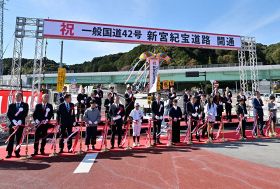 開通を祝いテープカットやくす玉割りをした関係者（７日、三重県紀宝町で）