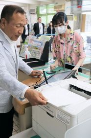 「書かない窓口」で証明書を発行する大江康弘町長（３日、和歌山県白浜町で）