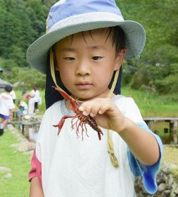 釣ったザリガニを持つ子ども