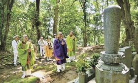 補陀洛山寺の裏山にある渡海上人の墓の前で読経する僧侶ら（１７日、和歌山県那智勝浦町浜ノ宮で）