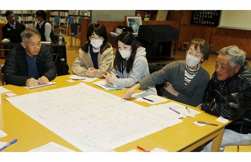 地域の行事や会議の一覧を見ながら議論する上芳養向上委員会のメンバー（和歌山県田辺市上芳養で）