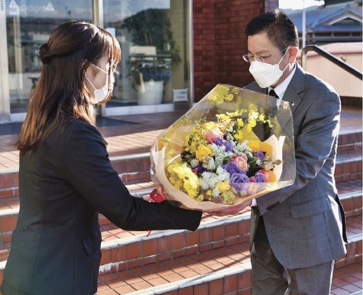 職員から花束を受け取る奥田誠町長（右）＝７日、和歌山県上富田町朝来で