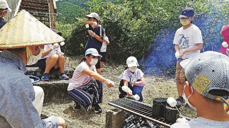 火をおこし、かまどでマシュマロを焼く参加者（和歌山県田辺市龍神村龍神で）