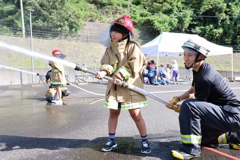 防火服を着て放水を体験する児童（和歌山県串本町サンゴ台で）