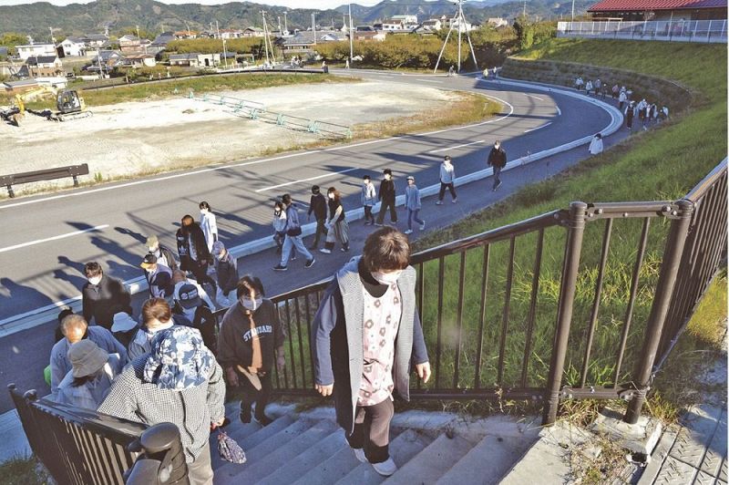 徒歩で高台の防災拠点エリアに向かう住民（６日、和歌山県みなべ町南道で）