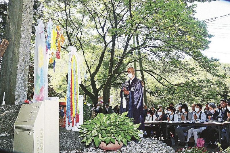 慰霊碑の前で読経する松本周和住職と参列者（５日、田辺市龍神村殿原で）