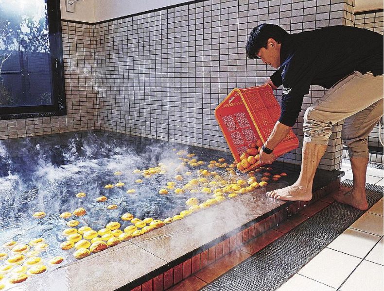 湯船にユズを入れる関係者（２２日、和歌山県串本町サンゴ台で）