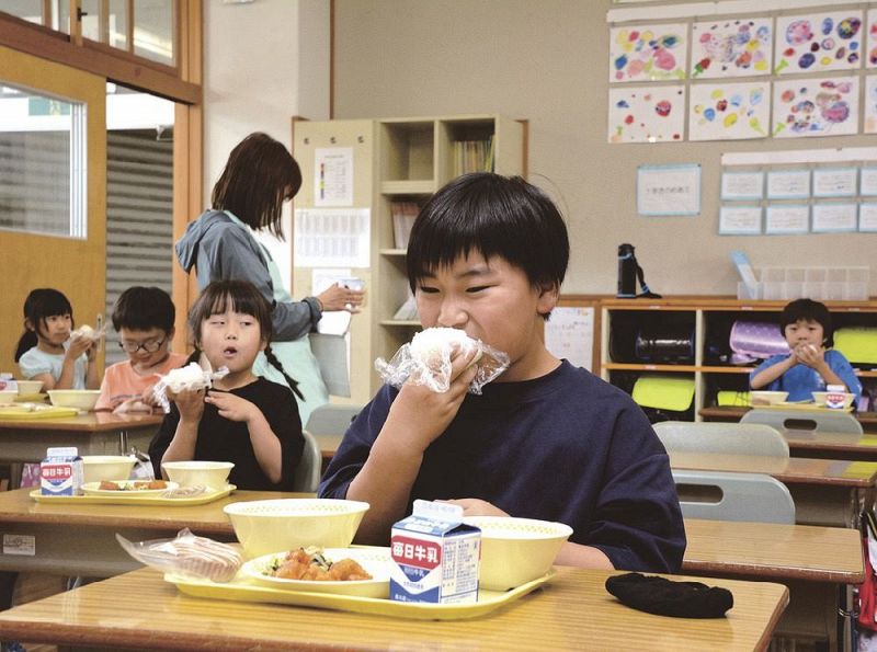 「梅の日」に梅干しおにぎりを頬張る子どもたち（２０２３年６月６日、和歌山県みなべ町で）