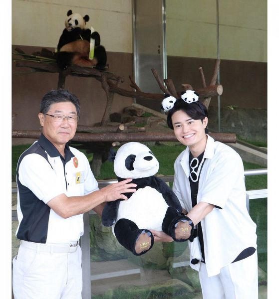 今津孝二園長（左）から就任の記念品としてパンダのぬいぐるみを受け取る「てぃ先生」＝２７日、和歌山県白浜町で