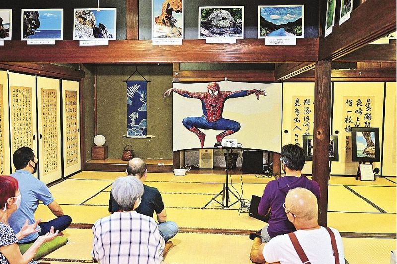 スパイダーマンの仮装で登場し、写真展を盛り上げる長谷洋さん（和歌山県古座川町小川で）