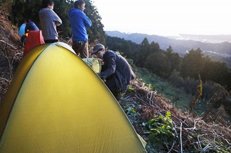 人里離れた梅の耕作放棄地で野営の準備をするリボーンプロジェクトメンバー（和歌山県田辺市上芳養で）