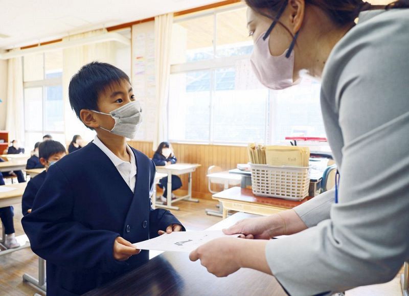 連絡簿を受け取る児童（２３日、和歌山県田辺市上秋津で）