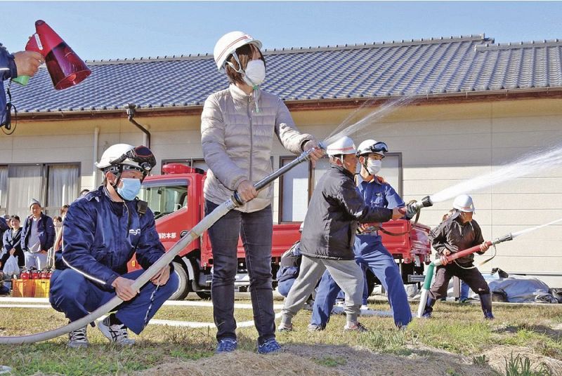 ３種類の口径のホースを持って放水体験をする訓練参加者（和歌山県白浜町庄川で）