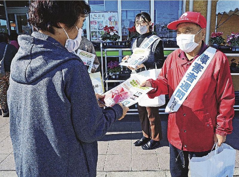 啓発品を手渡し障害者について関心や理解を深めてもらうよう呼びかける関係者ら（３日、田辺市稲成町で）