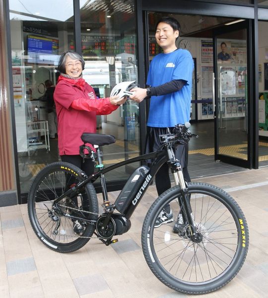 Ｅバイクを貸し出すサービスを始めるＪＲ西日本の石尾竜也さん（右）とクミッチの瀬戸陽子さん＝１日、和歌山県田辺市湊のＪＲ紀伊田辺駅前で