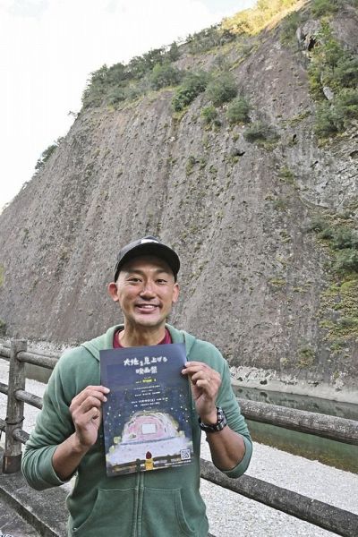 一枚岩での映画祭をアピールする実行委員長の田堀穣也さん（和歌山県古座川町相瀬で）