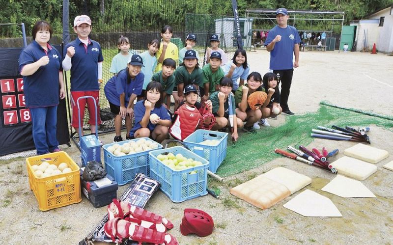 山口さん夫妻（左端）から南セニョリータスに寄付されたソフトボールの道具＝和歌山県田辺市芳養松原２丁目で