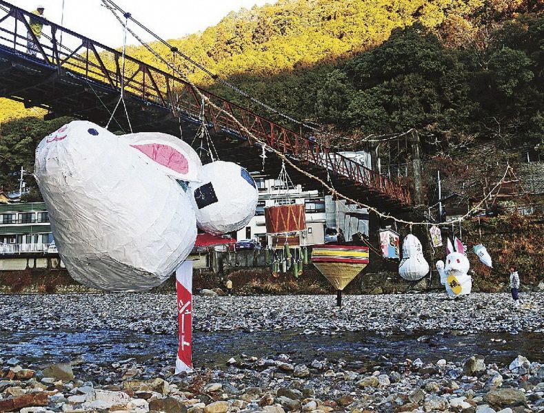 つり橋に沿ってつり下げられた張り子（和歌山県田辺市本宮町川湯で）