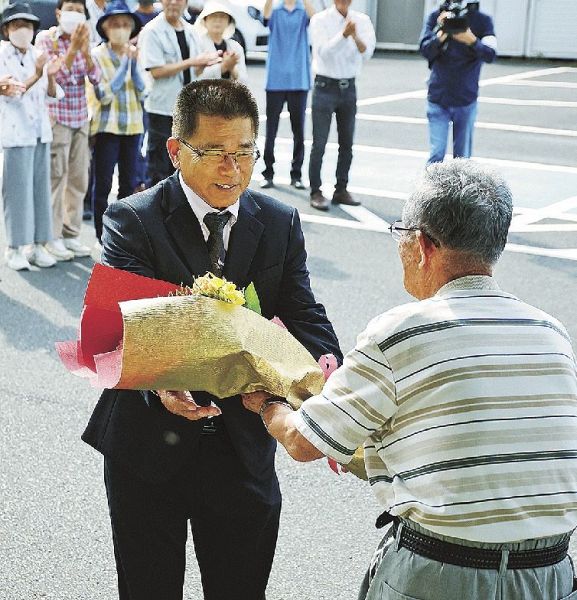 集まった支援者から花束を受け取る大屋一成町長（左）＝１７日、和歌山県古座川町高池で